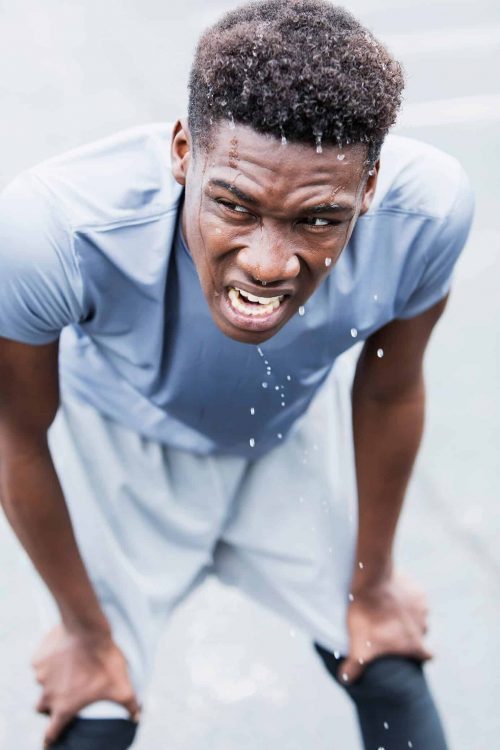 grimacing athlete with hands on knees