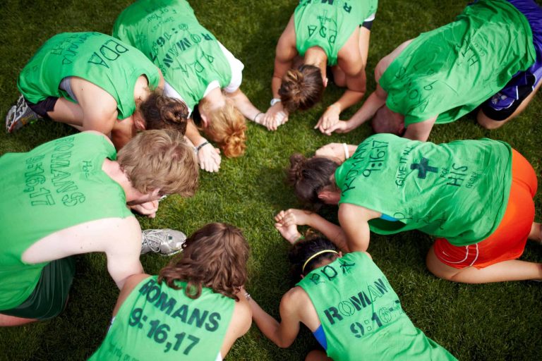 Group of women wearing green shirts praying