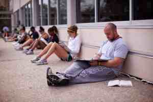 People sitting against the wall of a building