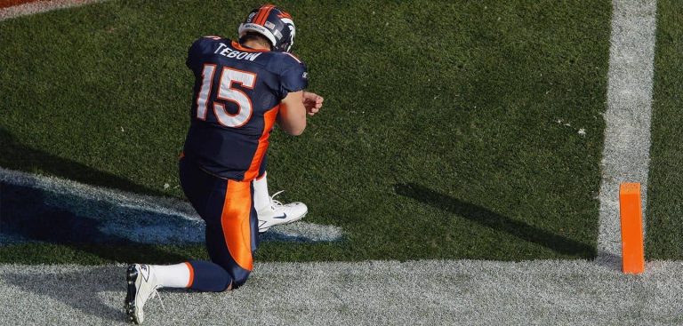american football athlete kneeling and praying