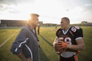 Football coach with player