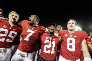 Men in red football jerseys arm in arm on field