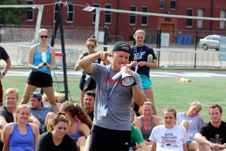 male staff member speaks to athletes with megaphone