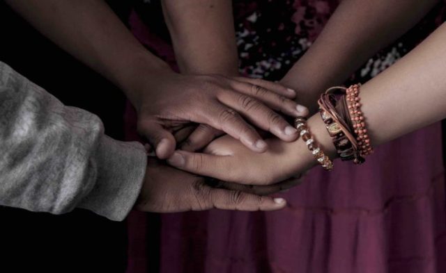 A group put their hands together in support of one another