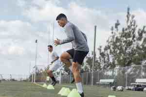 Soccer players performing warm up drills on field