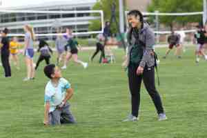 Trainer smiling at young boy on the field