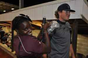 Sports performance trainer smiling as she holds ice on an athlete's shoulder