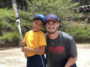 Trip participant with boy holding a bat