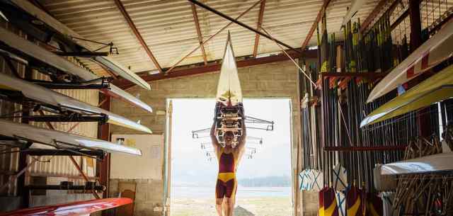 rowers carrying boat into boathouse