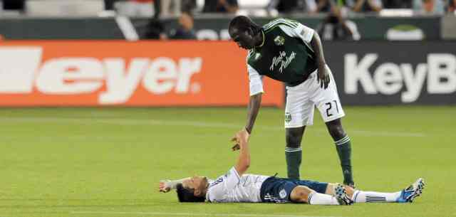 soccer player helps another player up