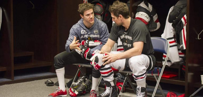 hockey athletes talking to each other in locker room