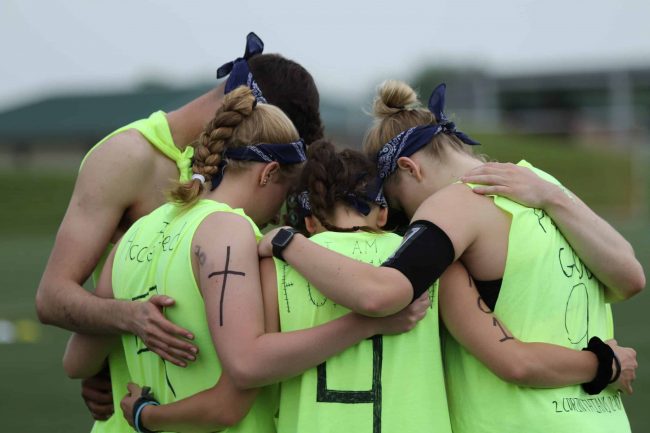 group of athletes in a prayer huddle