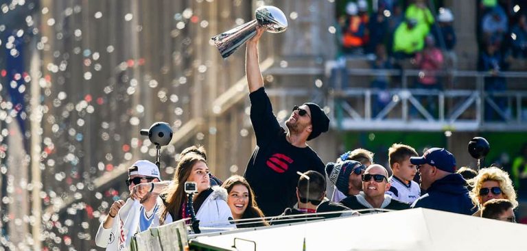 Man holding up super bowl trophy