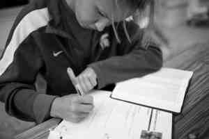 female athlete reading Bible and taking notes