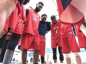 Men's basketball team circled up and praying