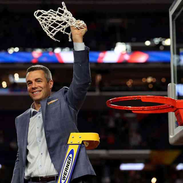 Coach Bennett on a ladder holding high the net he just cut from the basketball rim.