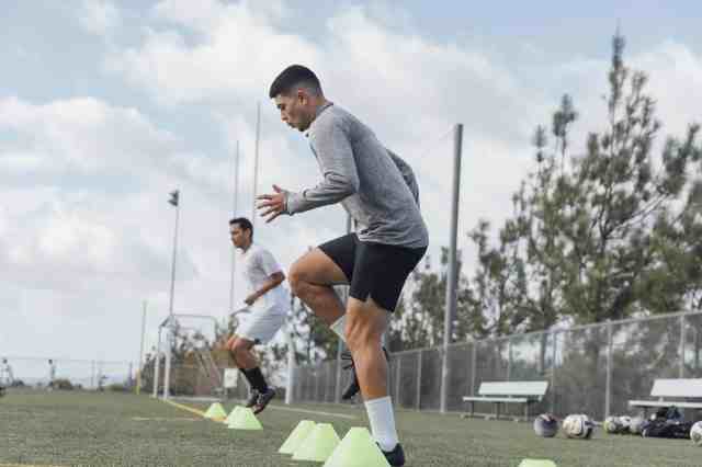 Soccer players performing warm up drills on field