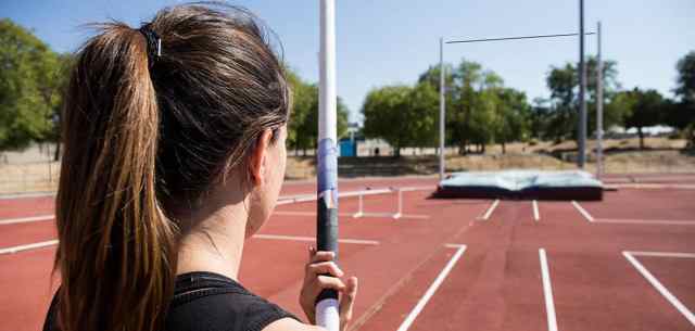 female pole vaulter facing bar