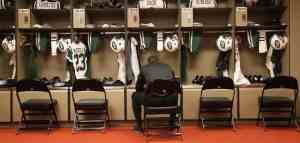 american football athlete sitting in front of his locker