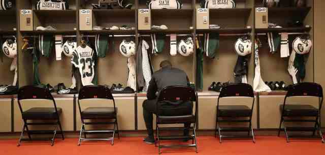 american football athlete sitting in front of his locker