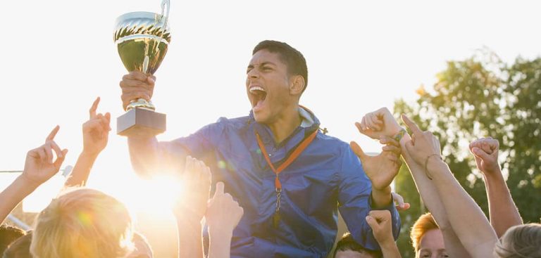 youth sports coach holding trophy