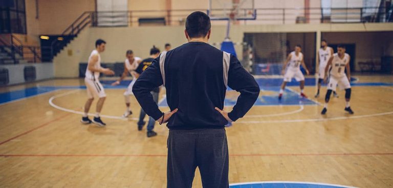 coach watching basketball players