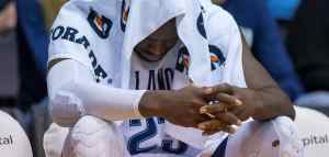 Athlete with head down & towel over his head