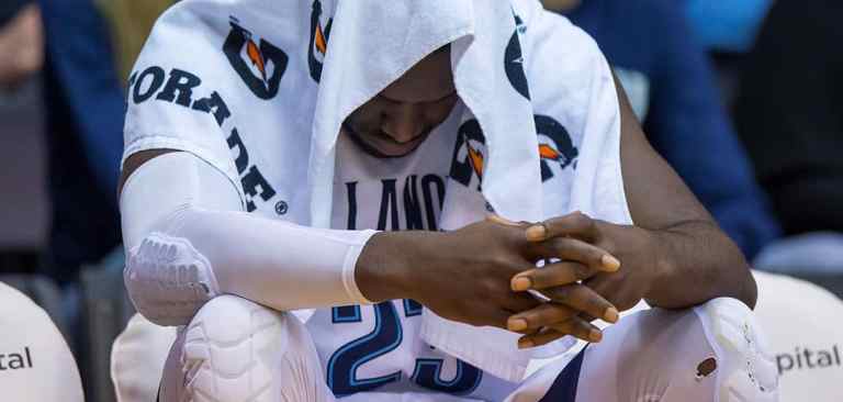 Athlete with head down & towel over his head