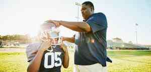 coach with youth american football player