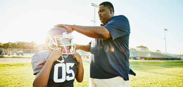 UR_parentcoach coach with youth american football player