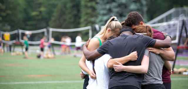 UR_prayforwin small group of students huddled in prayer
