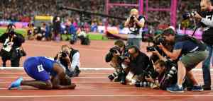 runner surrounded by camera men