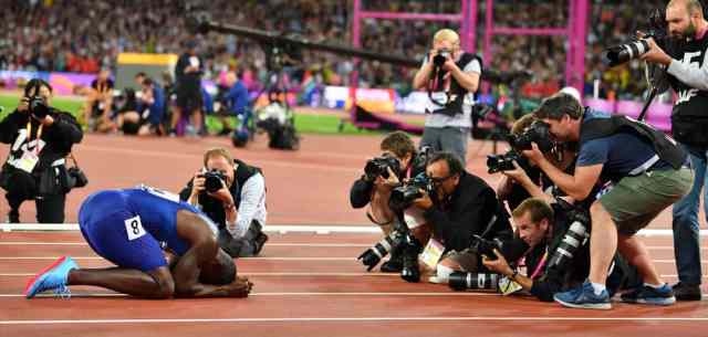 runner surrounded by camera men