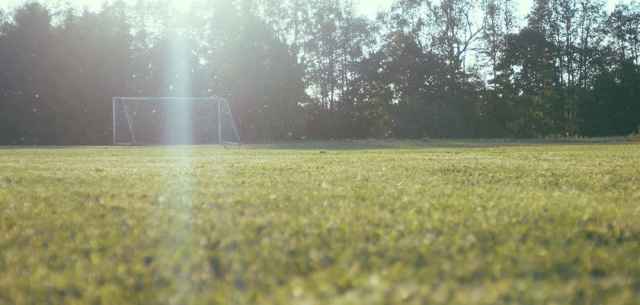 empty soccer field with goal net in the distance