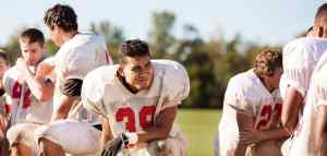 american football team with helmets off