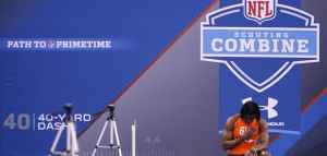 athlete standing in front of NFL combine sign
