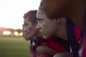 close up of woman looking out over a field with others beside her.