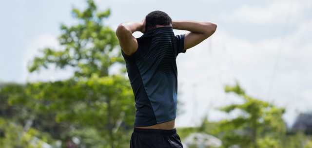 athletic man with shirt pulled over his face