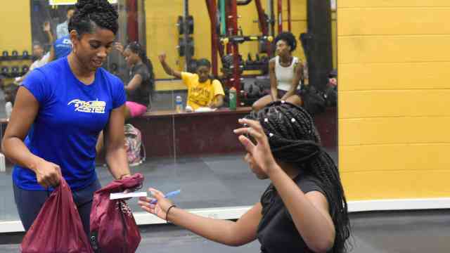 AIA Staff handing out Bibles to athletes