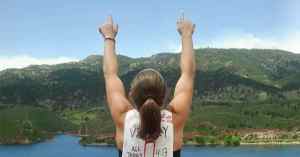Back of female athlete with index fingers pointed to the sky