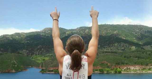 Back of female athlete with index fingers pointed to the sky