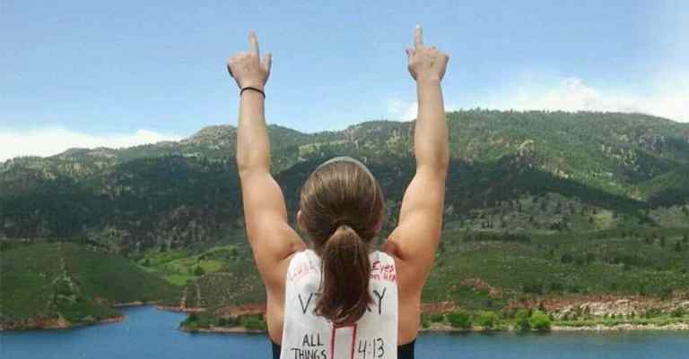 Back of female athlete with index fingers pointed to the sky