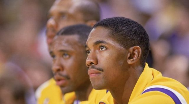 3 men in yellow uniforms sitting together, looking up