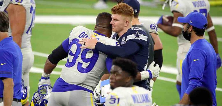 Andy Dalton hugging a professional football player from an opposing team