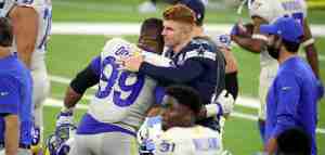 Andy Dalton hugging a professional football player from an opposing team