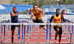Facing a man going over a hurdle in a race
