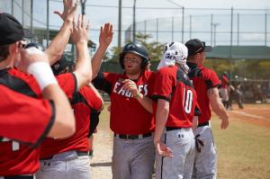 baseball players in red uniform shirts and white pants giving high 5's on the field
