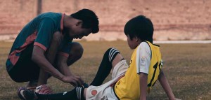man checking on young athlete