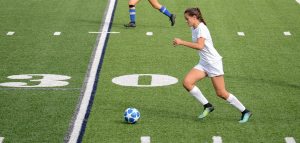 female soccer athlete kicking ball