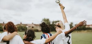 female sports team. one woman holds a trophy up